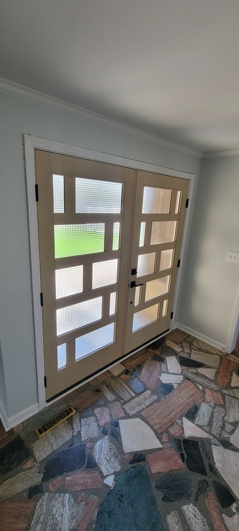 A room with a brick floor and a sliding glass door.