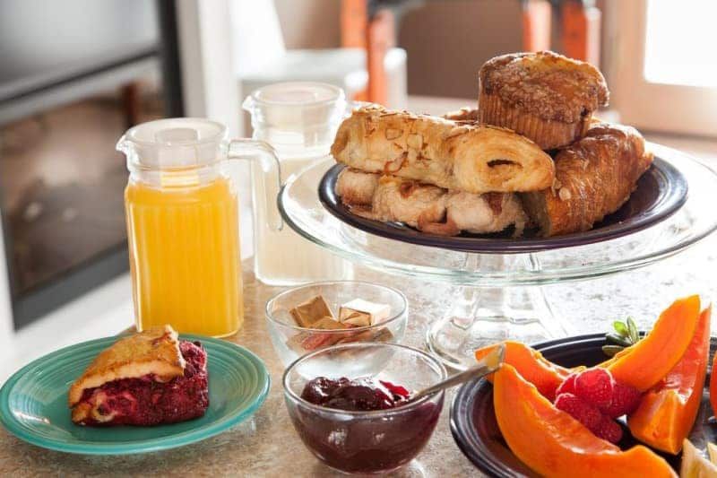 A table topped with plates of food and a pitcher of orange juice.
