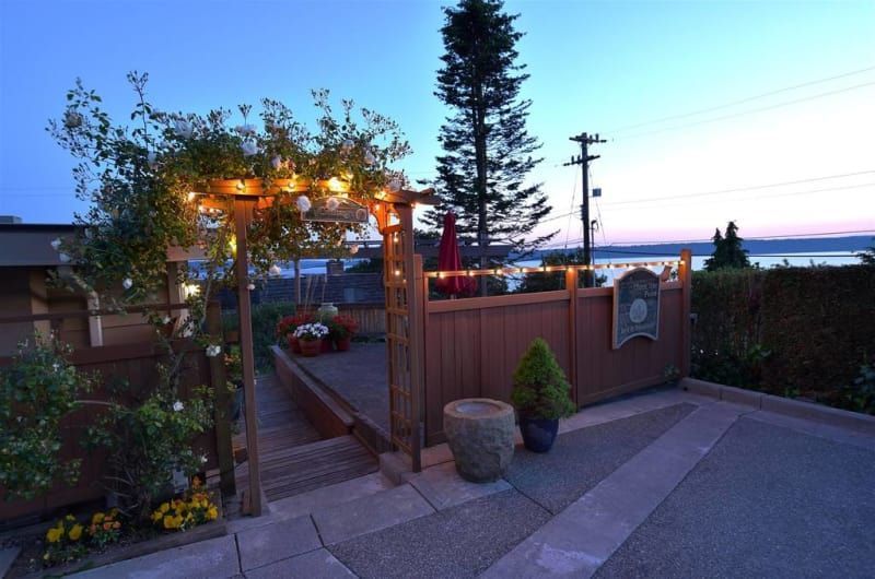 A patio with a wooden fence and a view of the ocean