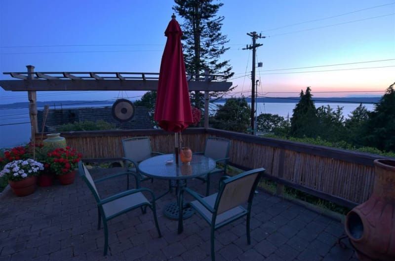 A patio with a table and chairs and a red umbrella