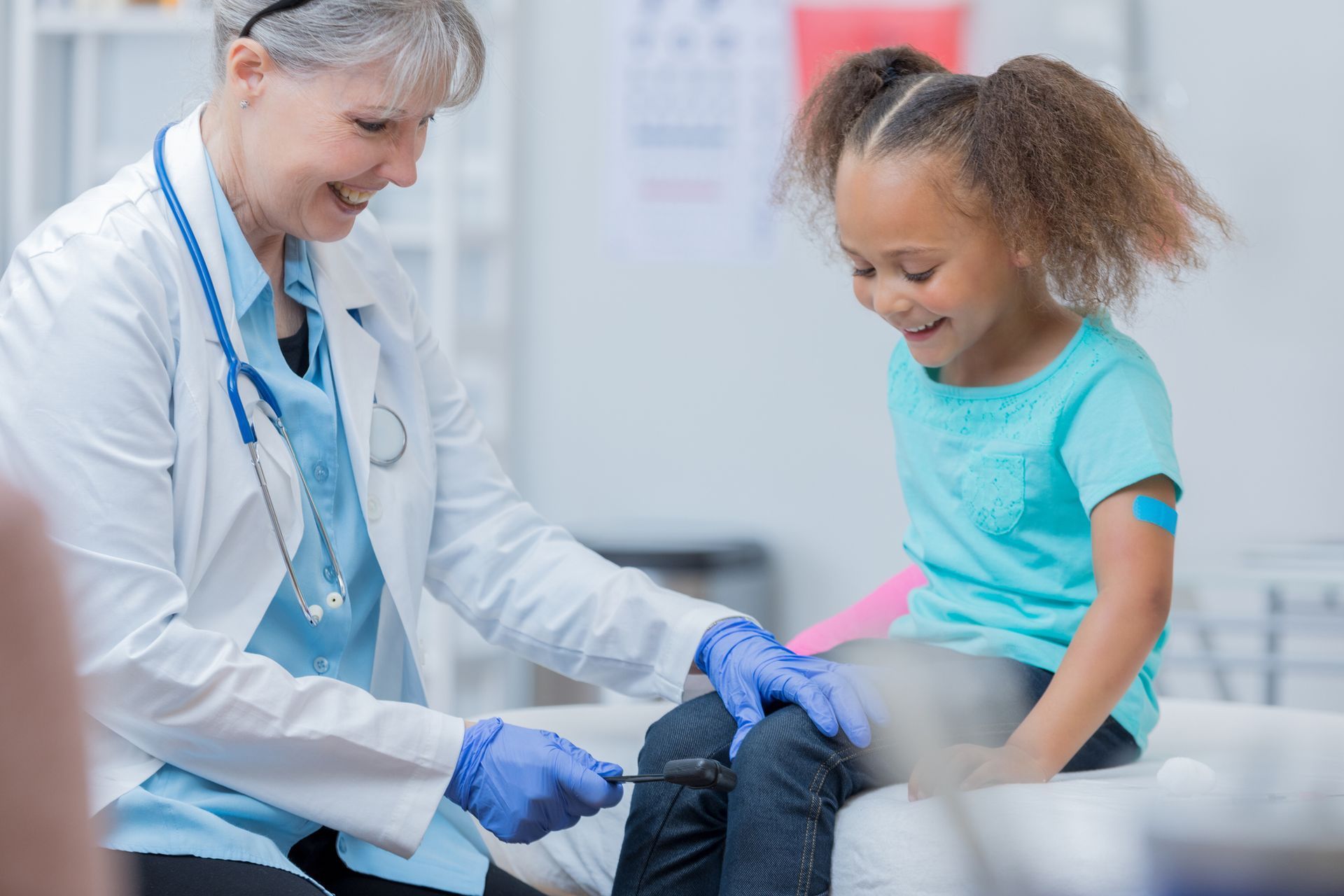 Doctor checks girls reflexes