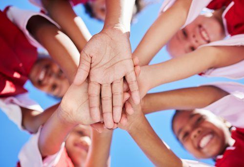 kids putting their hands together in a circle