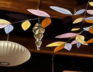 A bunch of colorful leaves are hanging from the ceiling