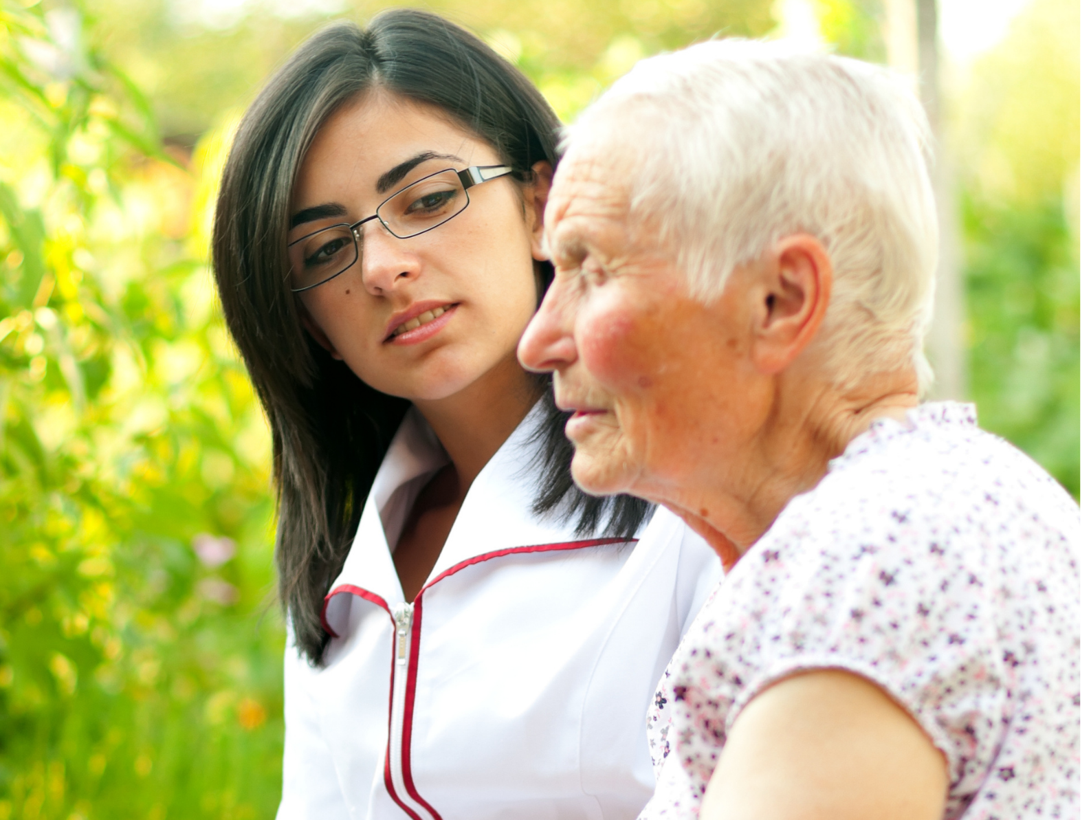 a woman is talking to an older woman who is wearing glasses .