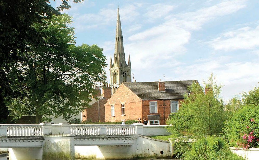 A bridge over a river with a church in the background