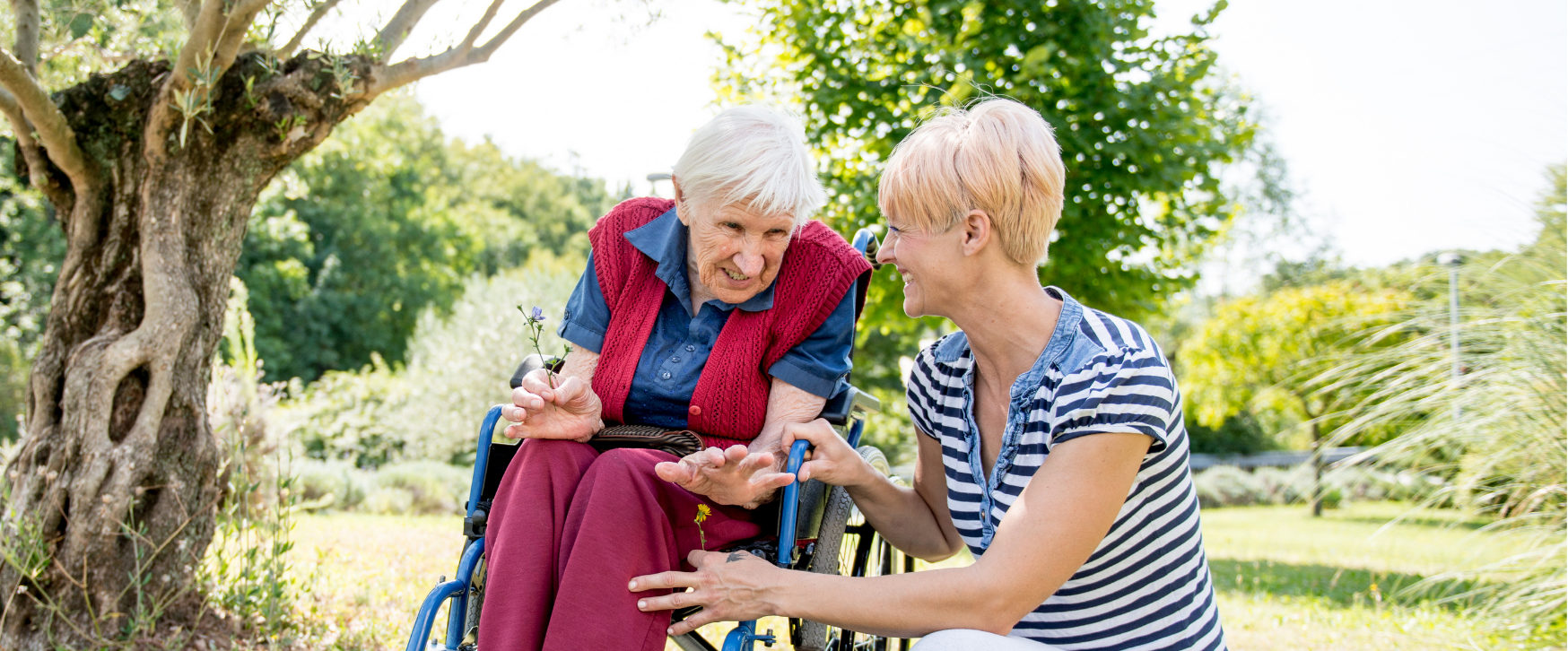 an elderly woman in a wheelchair is sitting next to a woman in a striped shirt .