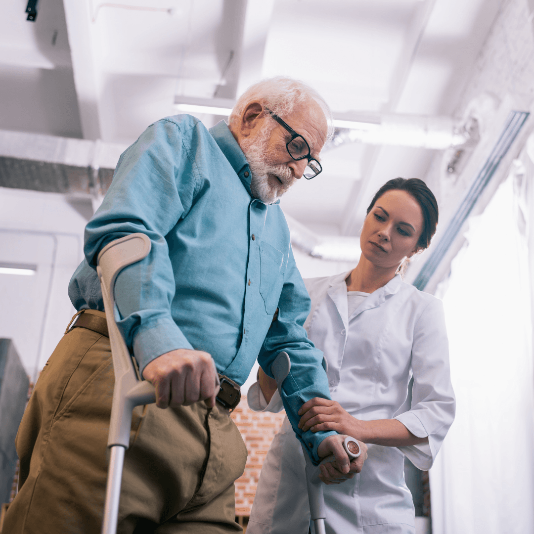 an elderly man with crutches is being helped by a nurse .