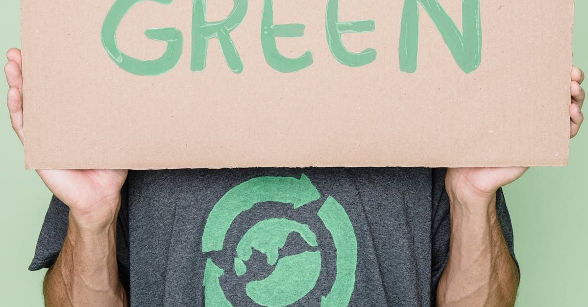A man is holding a cardboard sign over his head that says `` green ''.