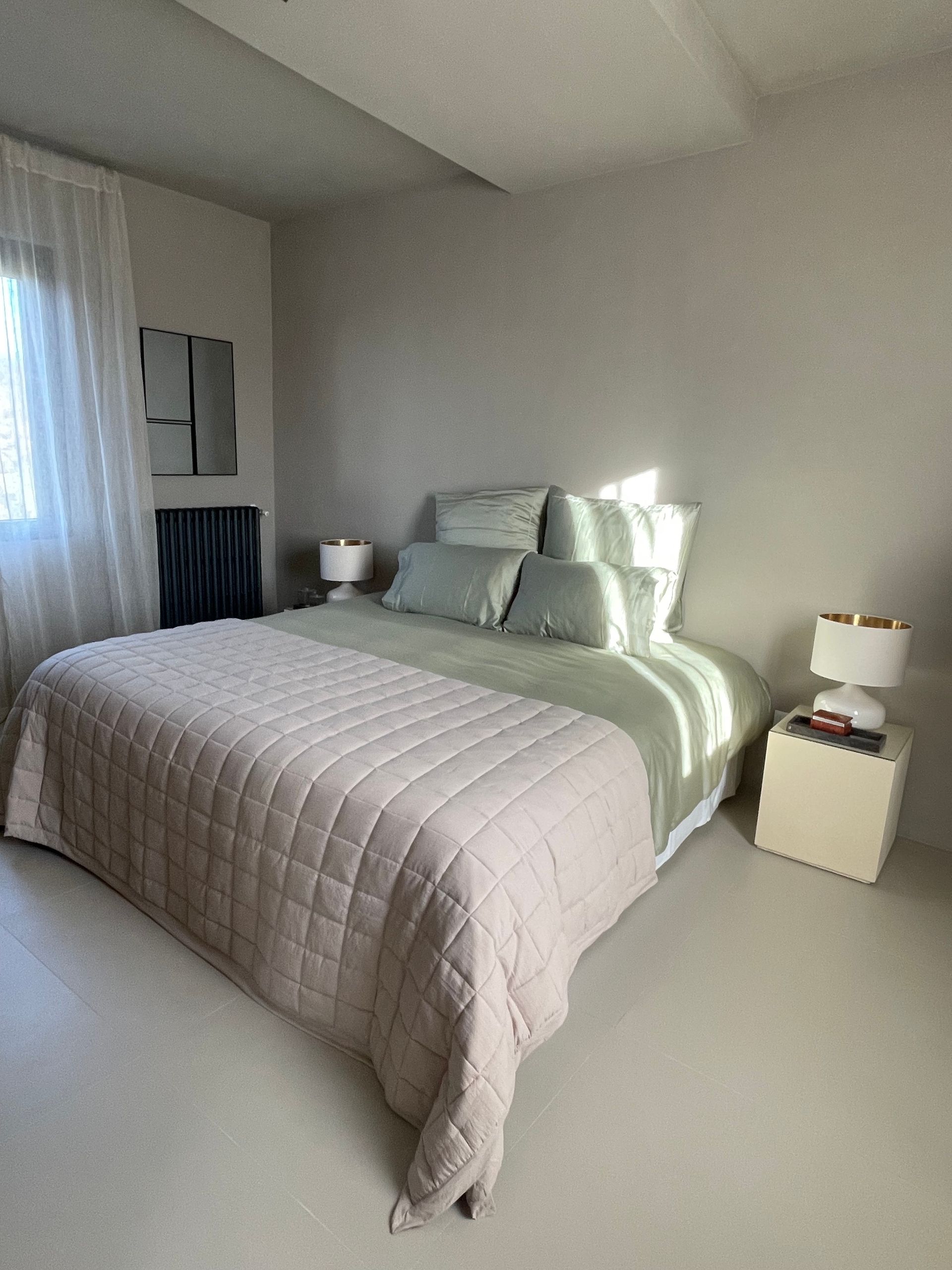 Bedroom with a bed, neutral color scheme, and sunlight.