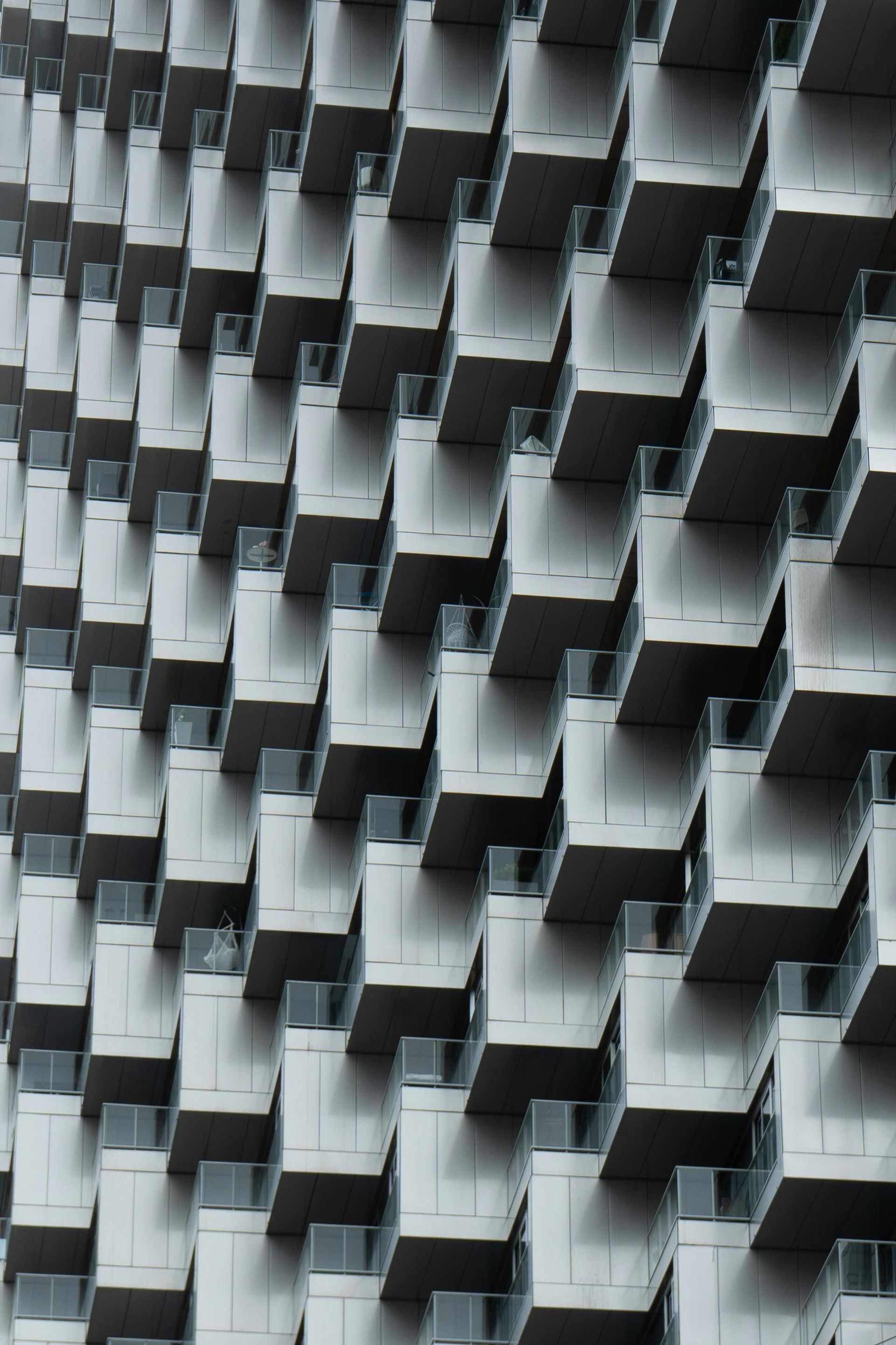 Exterior view of modern high-rise building with many projecting square balconies.