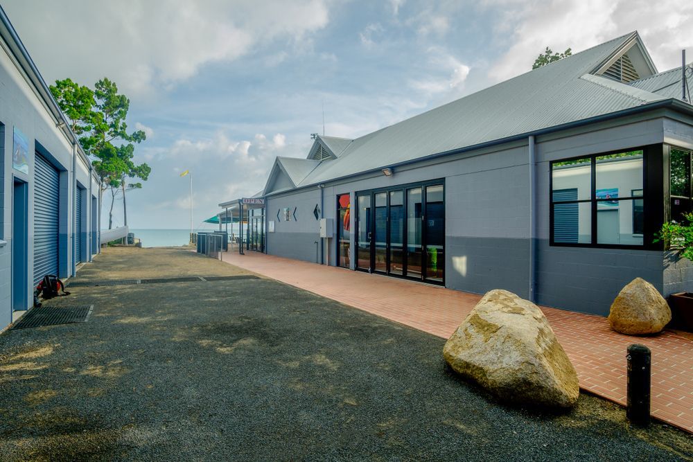 A Large Building with a Lot of Windows and a Large Rock in Front of It — Sun Cool Pools & Spas in Hervey Bay, QLD