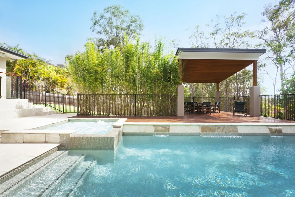 There Is a Large Swimming Pool in The Backyard of A House — Sun Cool Pools & Spas in Gympie, QLD