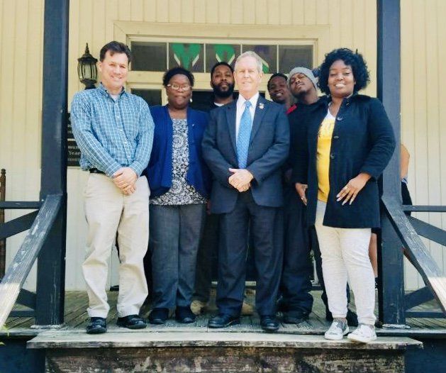 A group of people posing for a picture on a porch