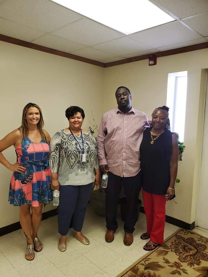 A group of people are posing for a picture in a room.