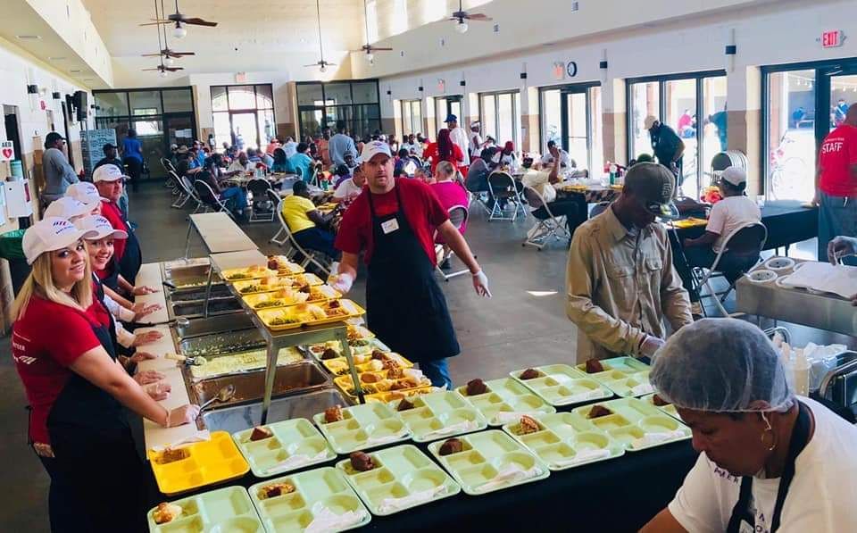 A group of people are preparing food in a large room.