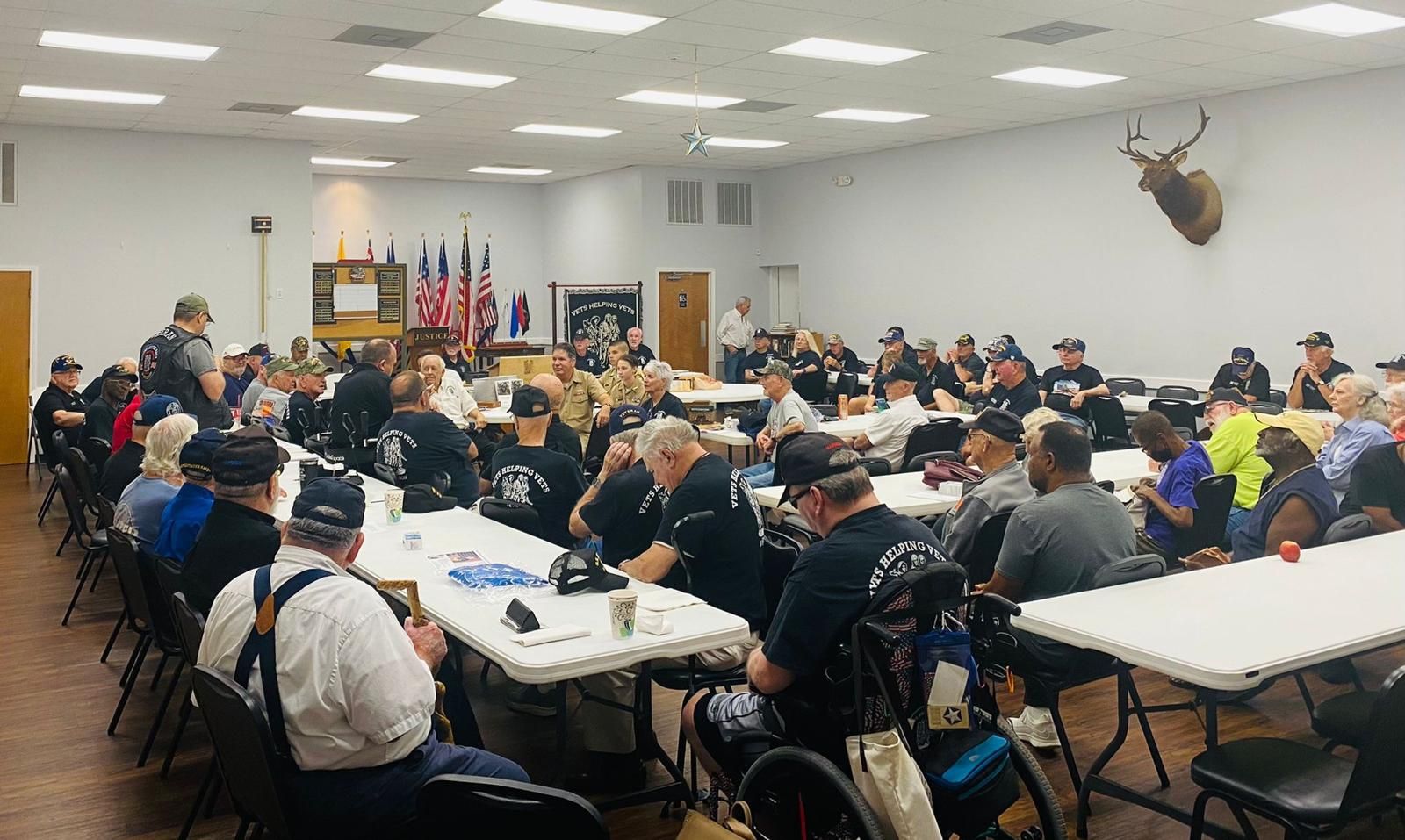A large group of people are sitting at tables in a room.