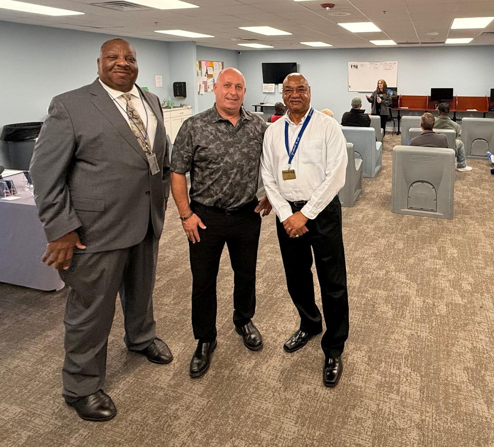 Three men are posing for a picture in a conference room