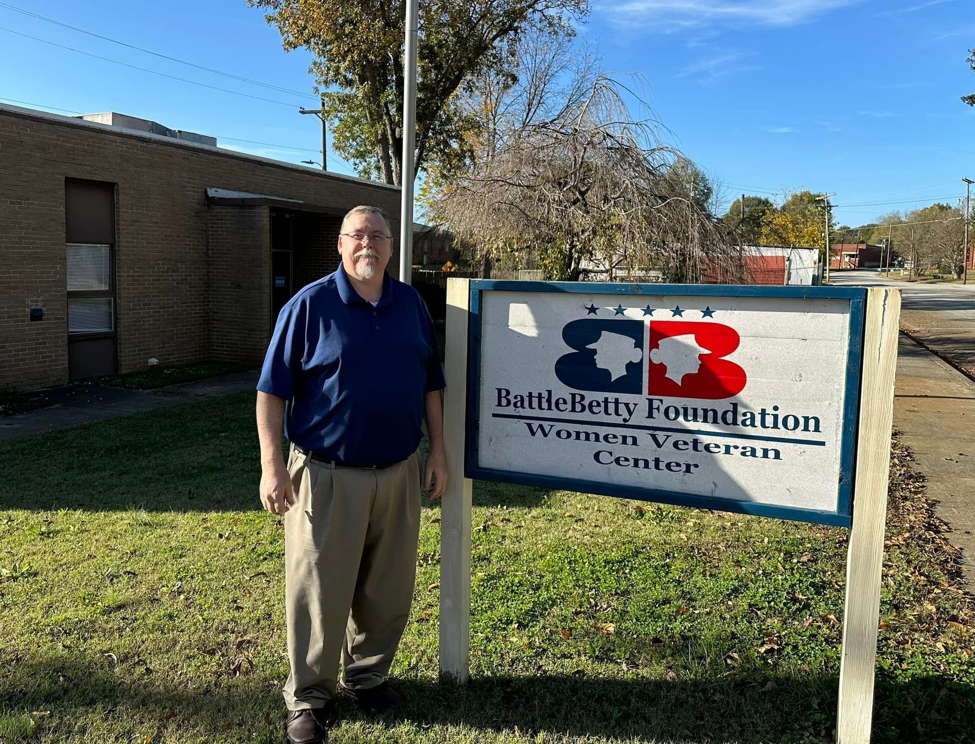 A man is standing in front of a sign that says battlebetty foundation