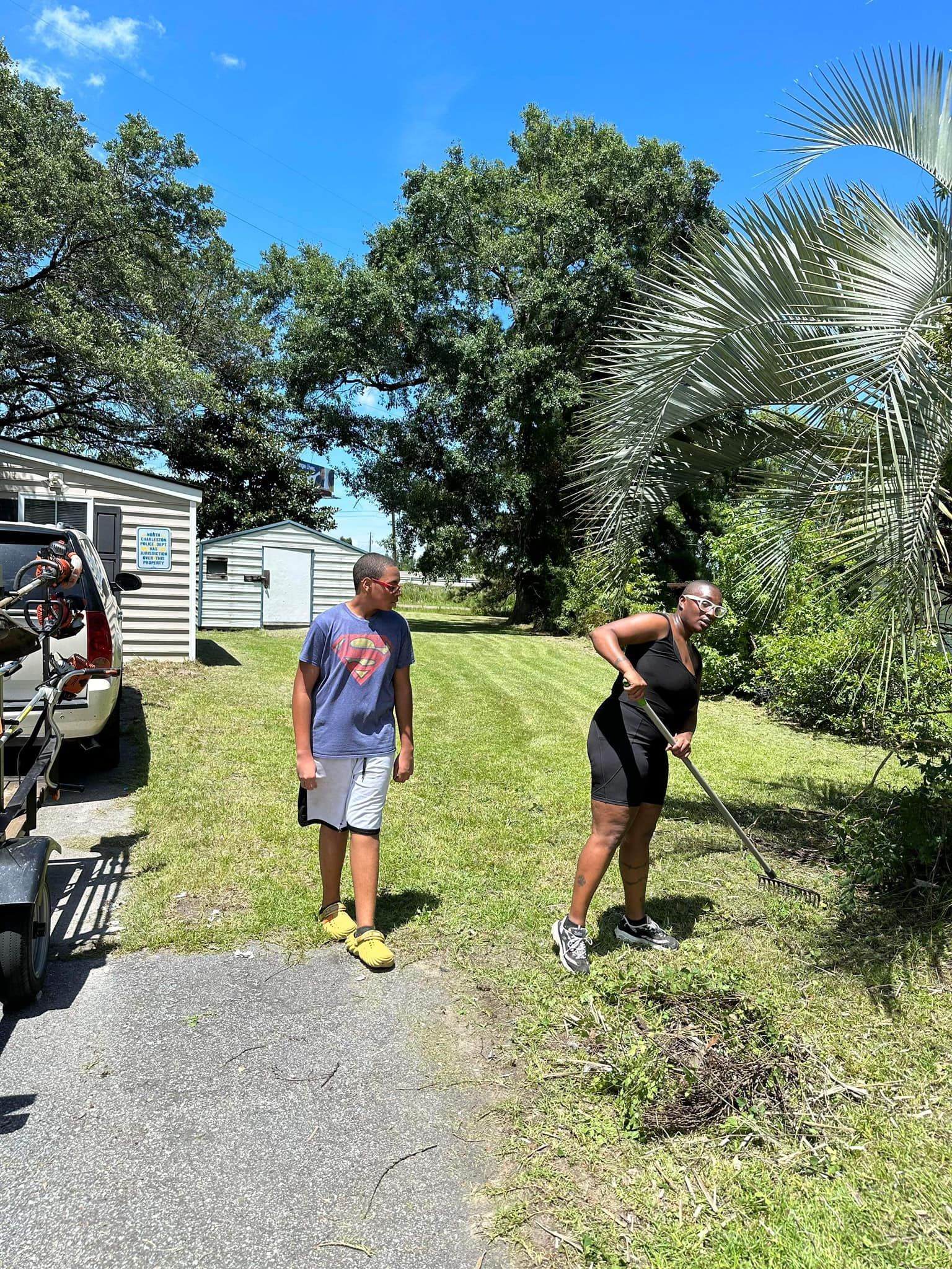 A man and a woman are standing in the grass in front of a house.