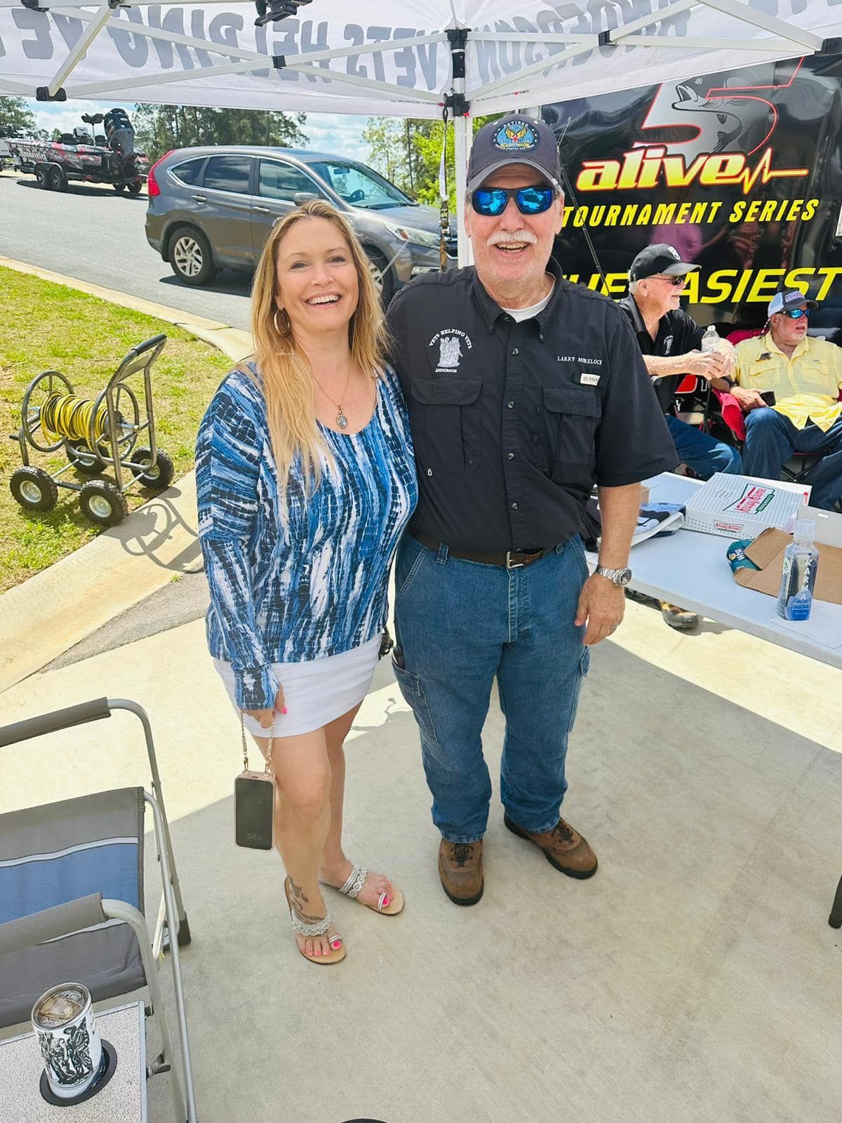 A man and a woman are posing for a picture in front of a tent.