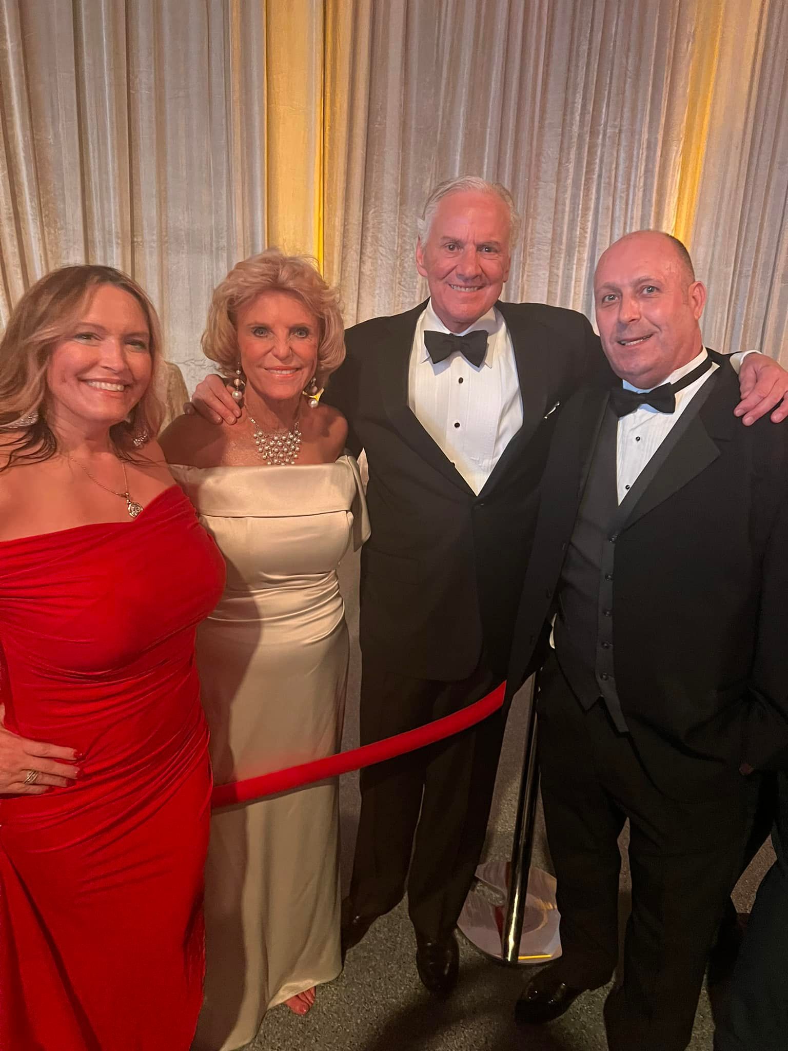 A group of people are posing for a picture in front of a red carpet.