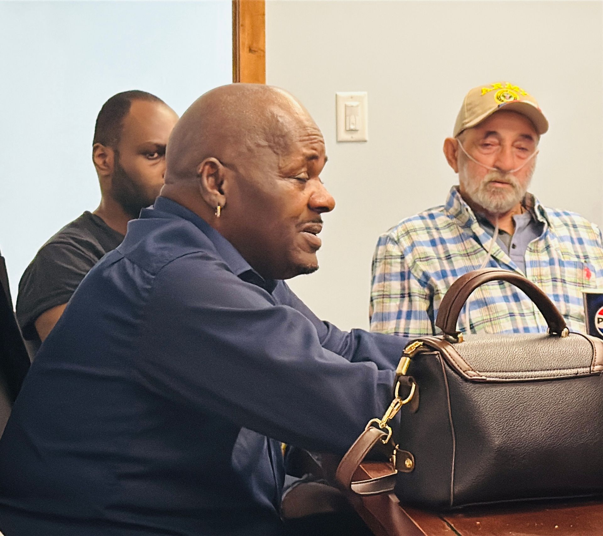 A man sitting at a table with a purse on it