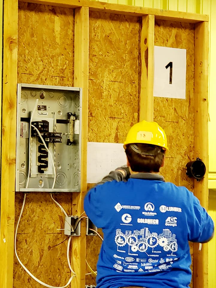 A man wearing a hard hat and a blue shirt with the number 1 on it