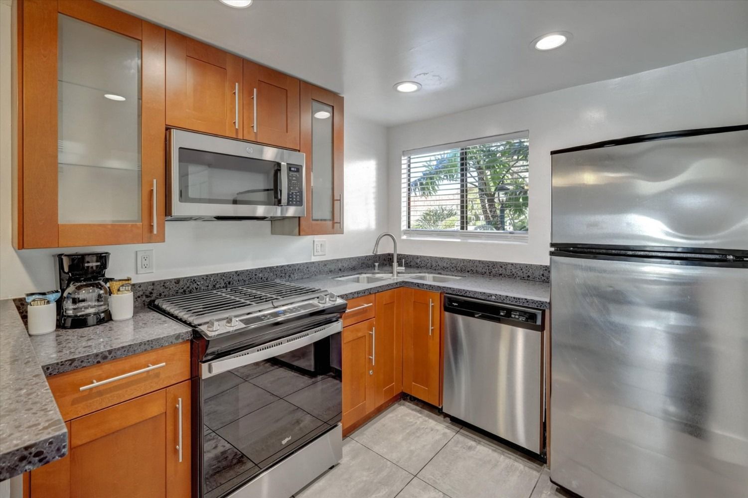 Modern kitchen featuring wood cabinets, stainless steel appliances, and gray countertops.