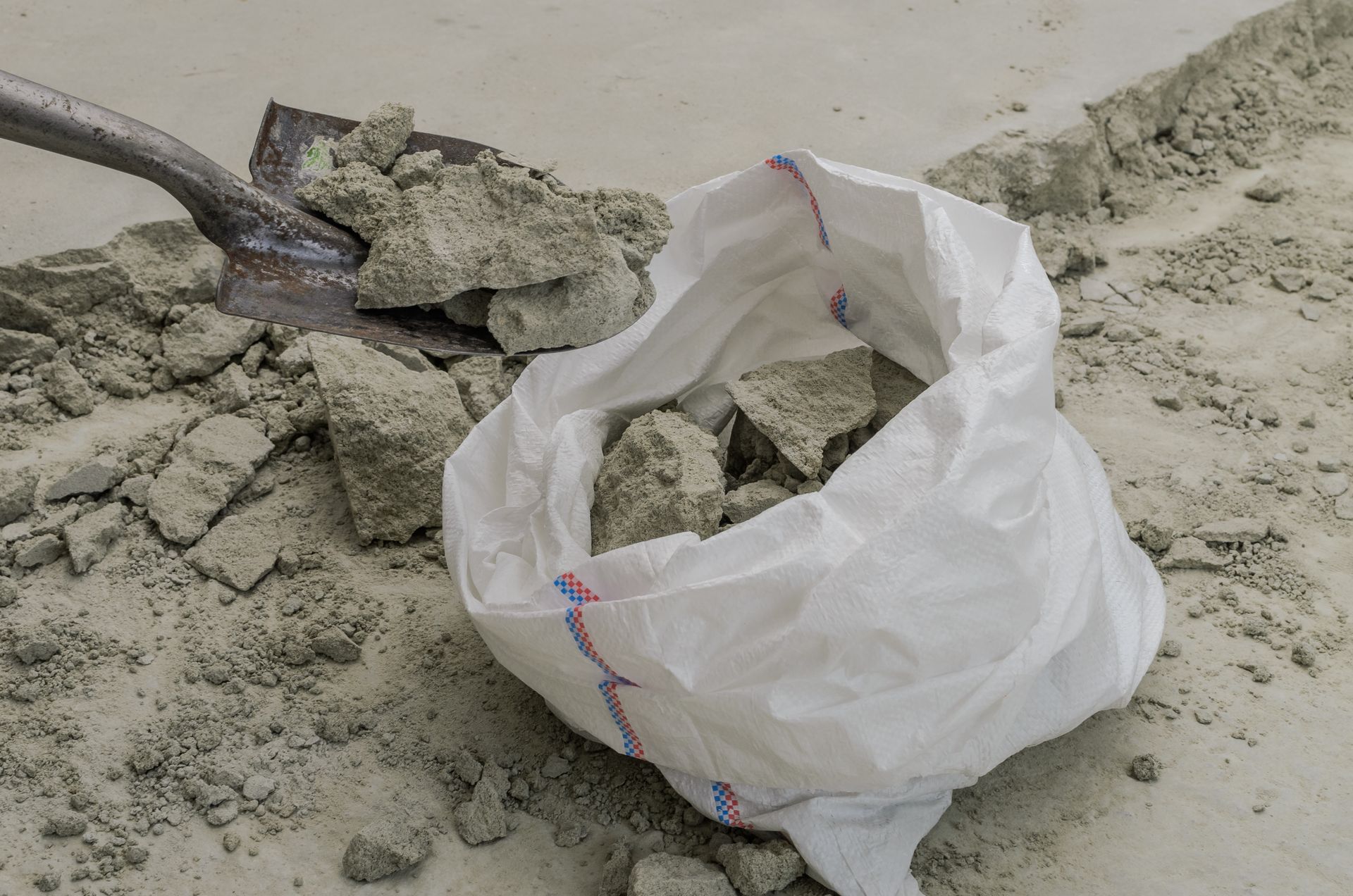 a shovel is laying on top of a bag of dirt .