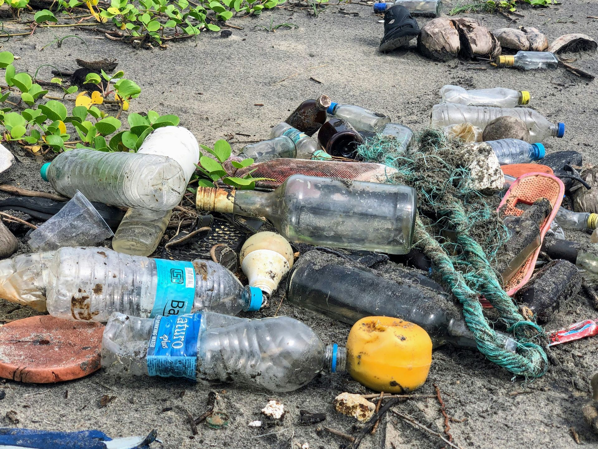 a pile of plastic bottles and other trash on a beach .