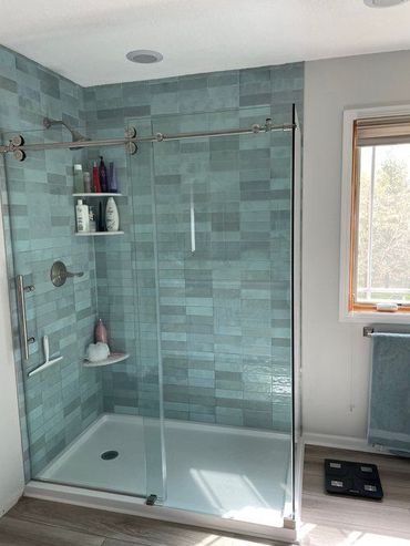 Modern white house with a pool, wood deck, and large windows. Blue water and sky.