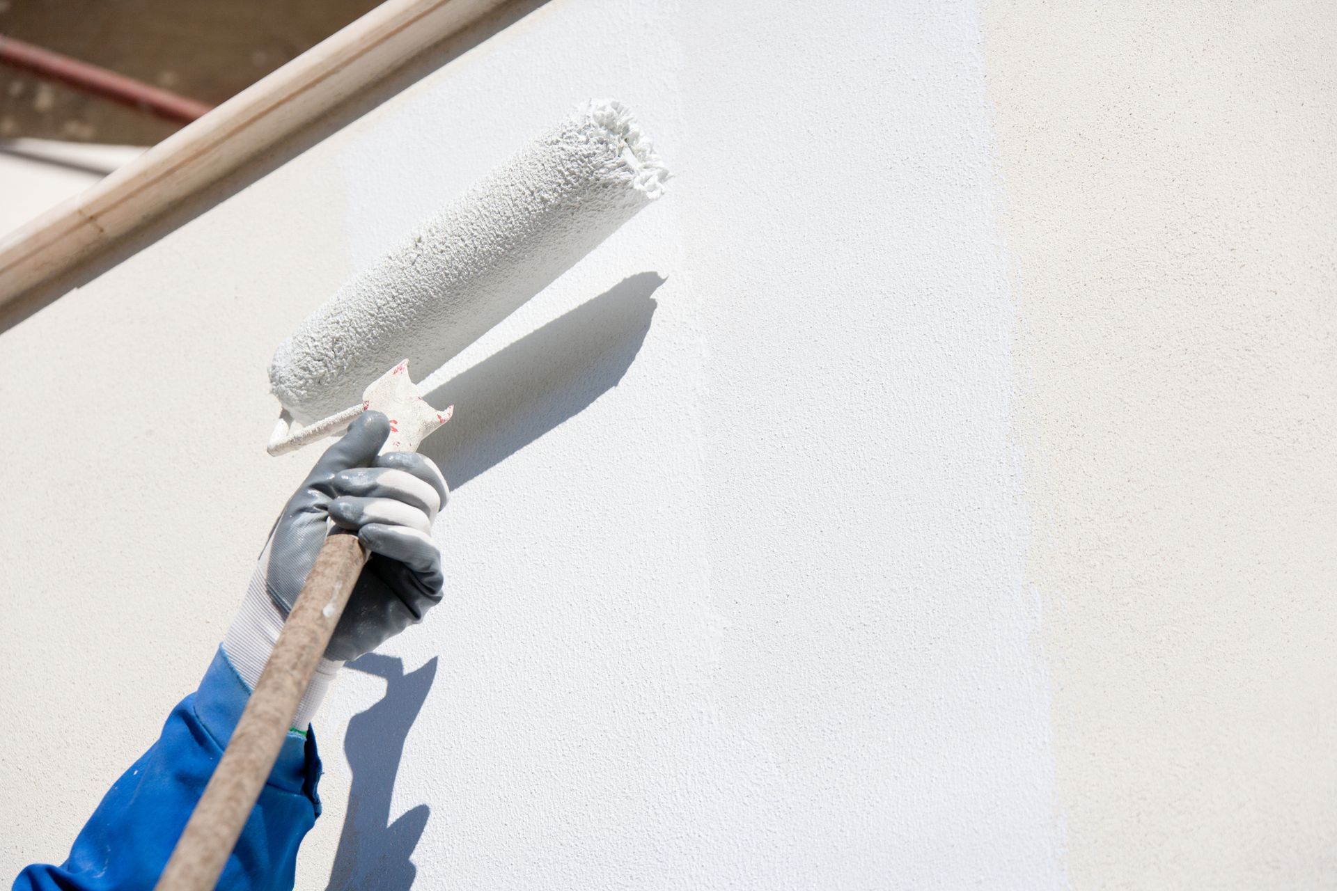 A person is plastering a wall with a trowel.