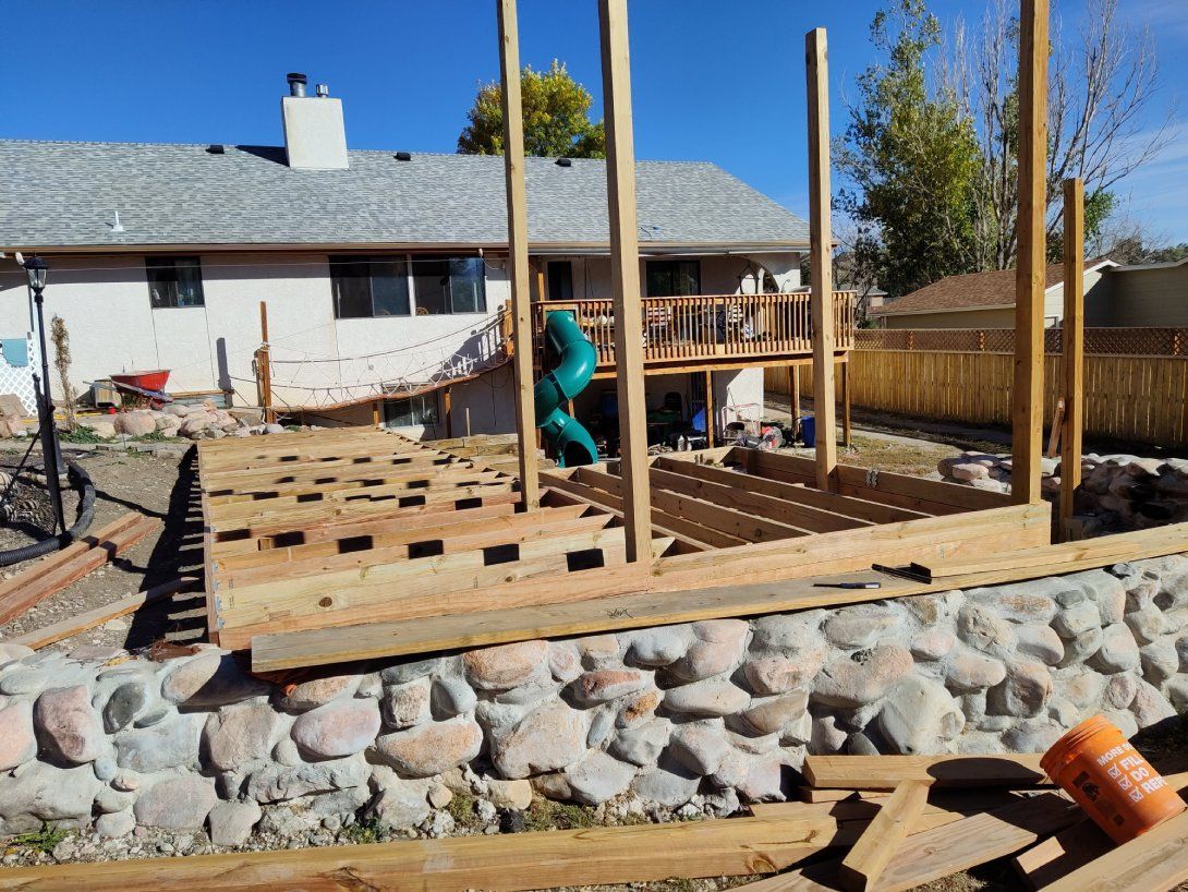 A wooden deck is being built in front of a house.