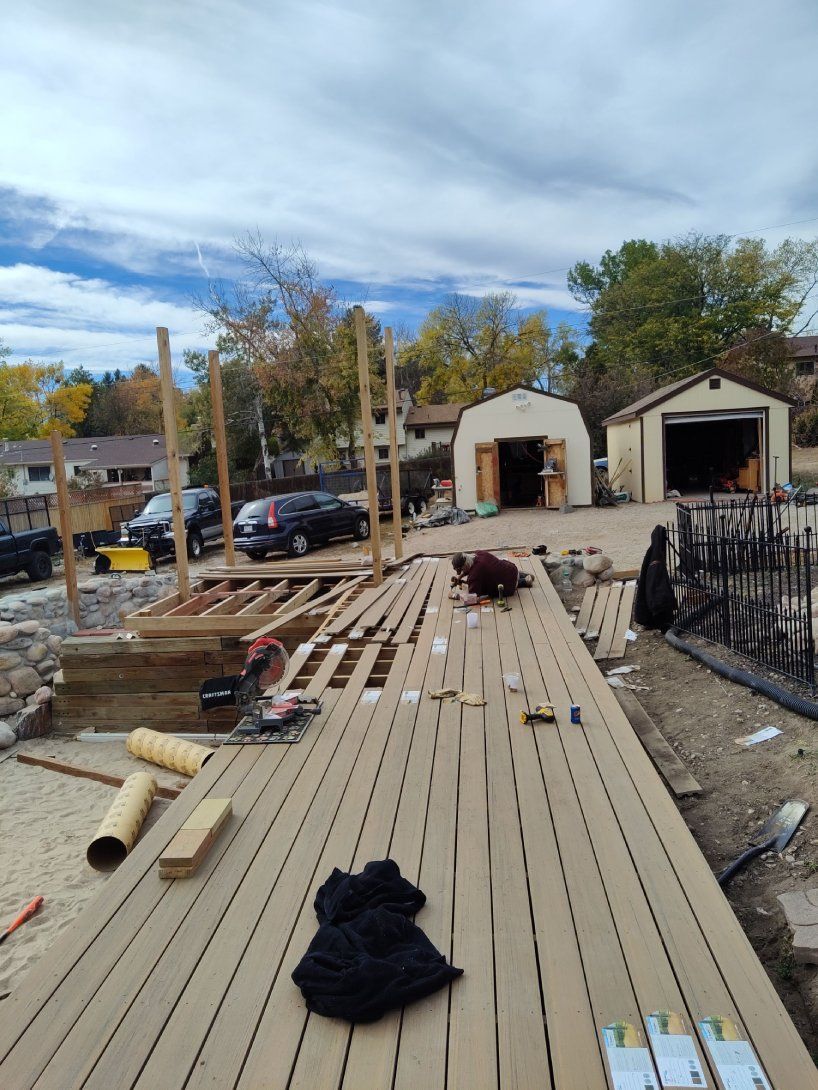 A wooden deck is being built in the backyard of a house.