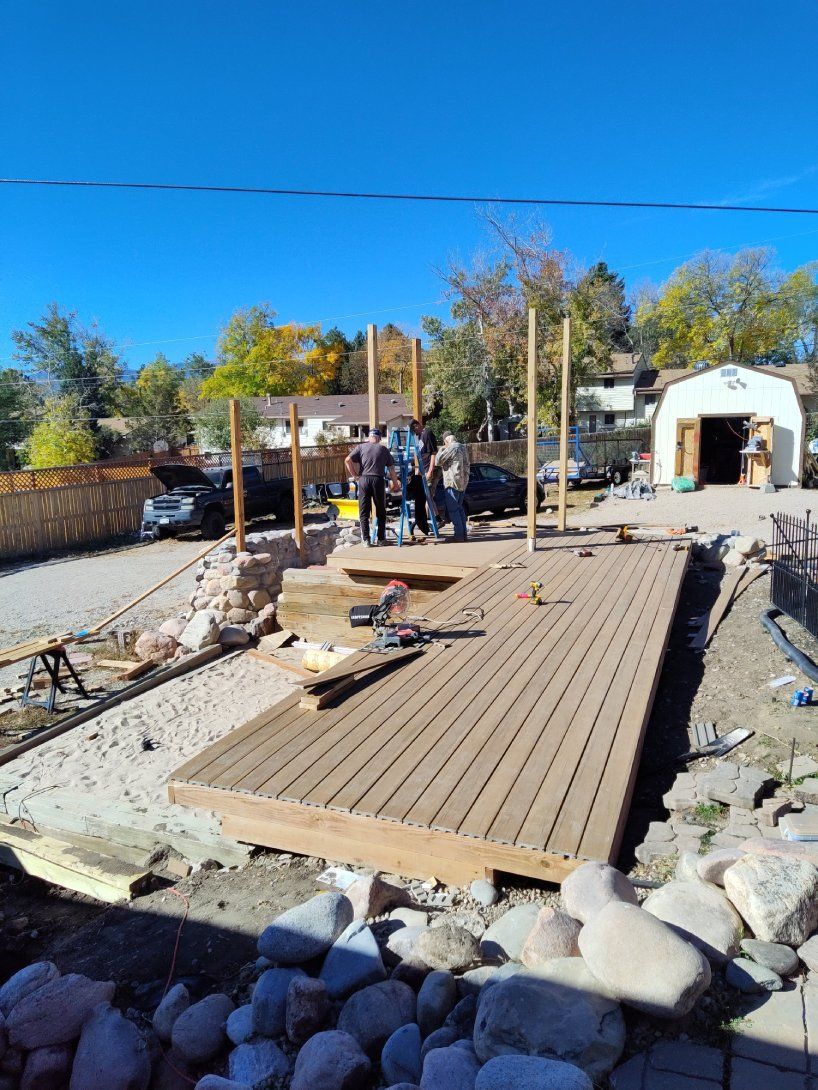 A group of people are working on a wooden deck.