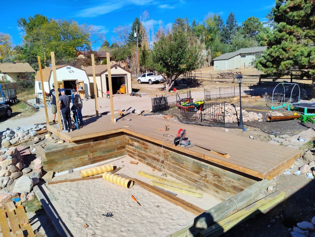 A group of people are working on a swimming pool in a backyard.