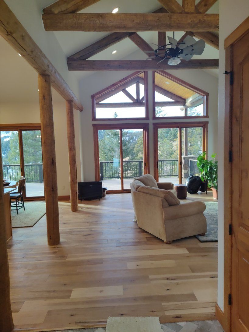A living room with a lot of windows and a ceiling fan