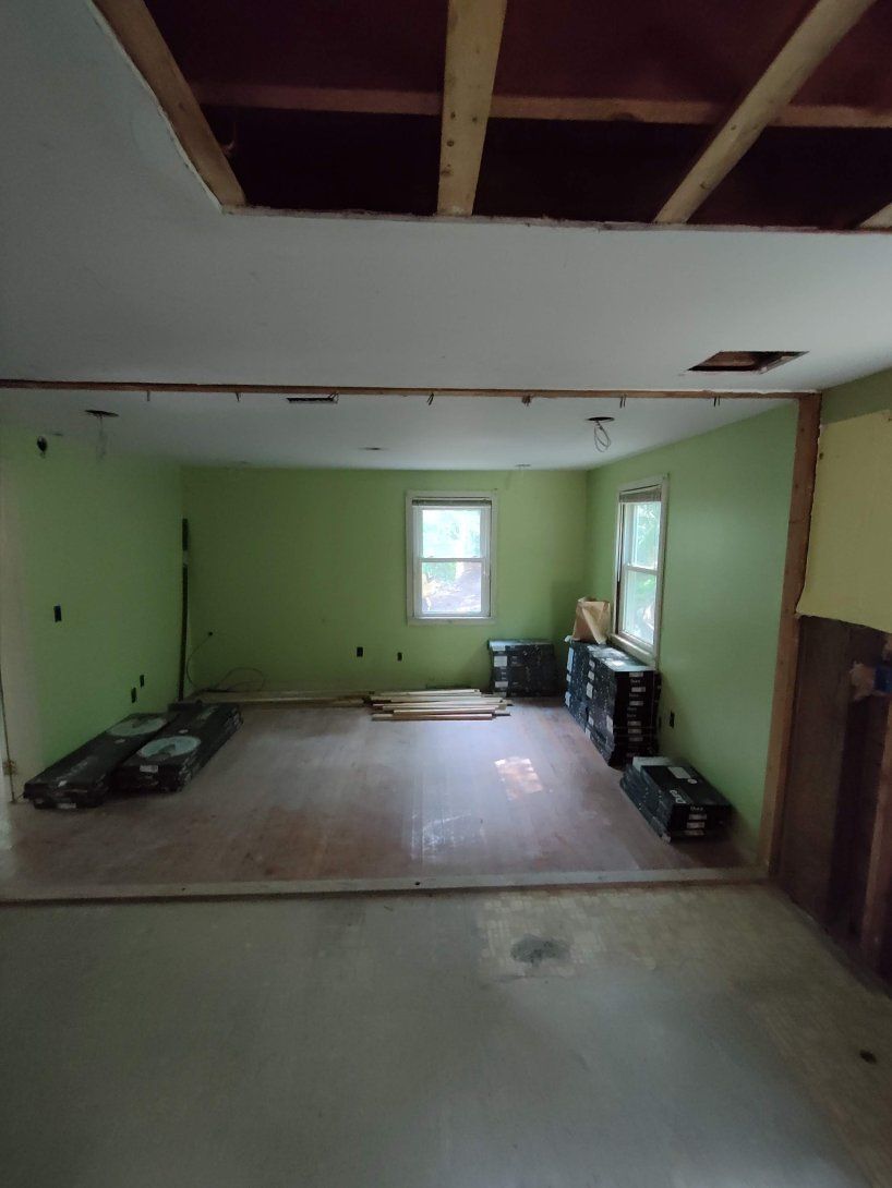 A room with green walls and a white ceiling is being remodeled.