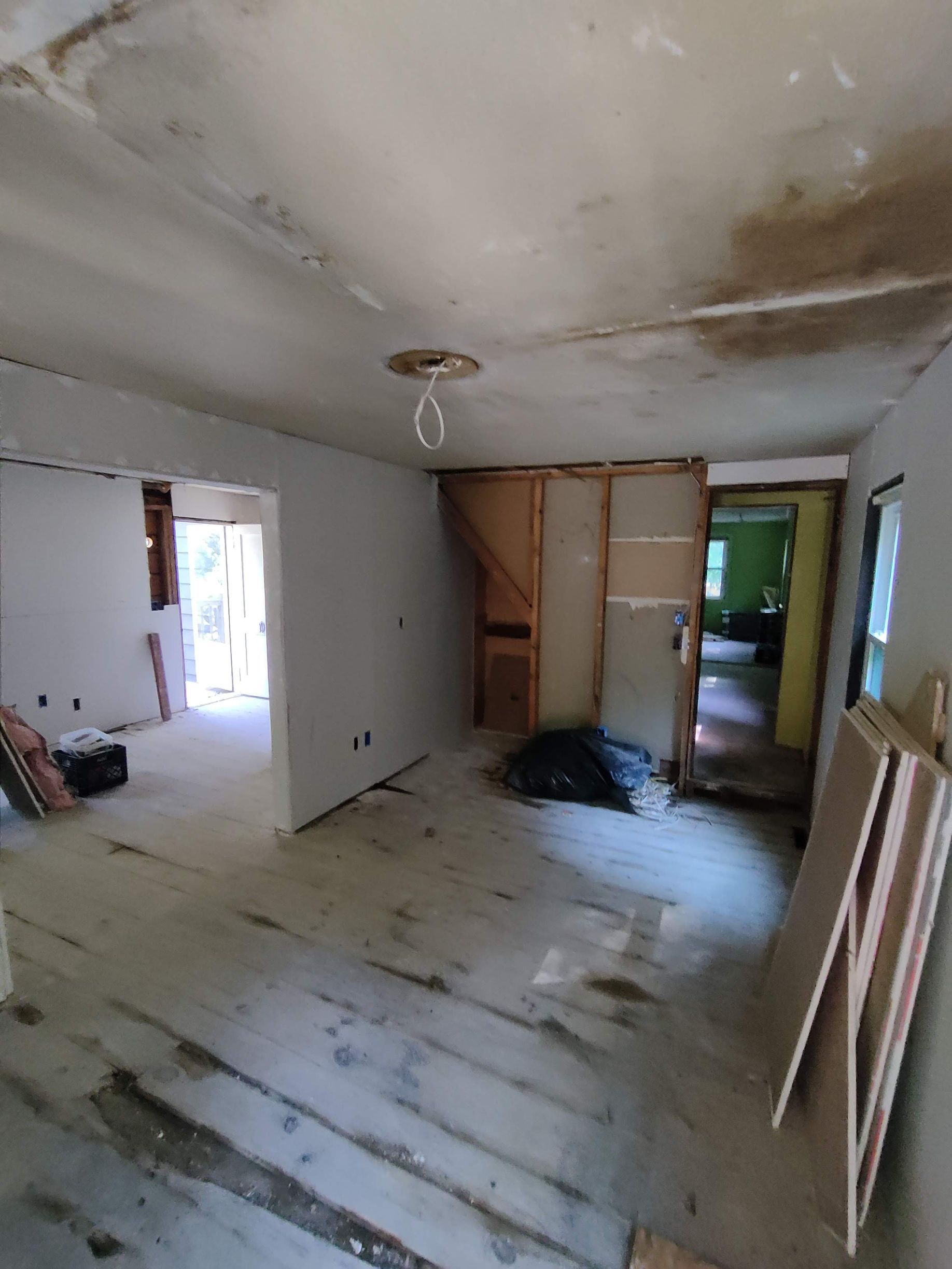 A room with a wooden floor and a ceiling that is being remodeled.