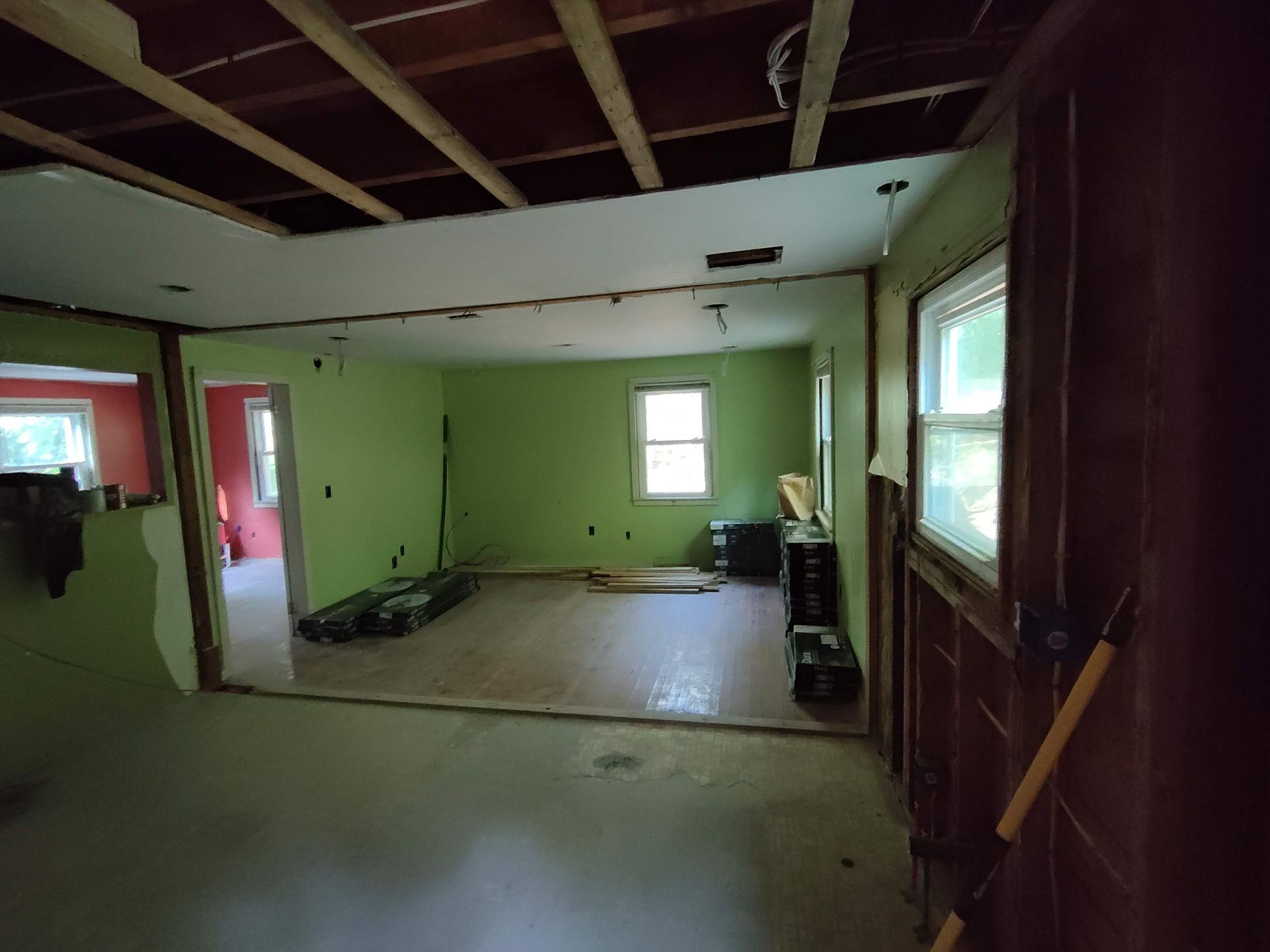 A room with green walls and a wooden ceiling is being remodeled.