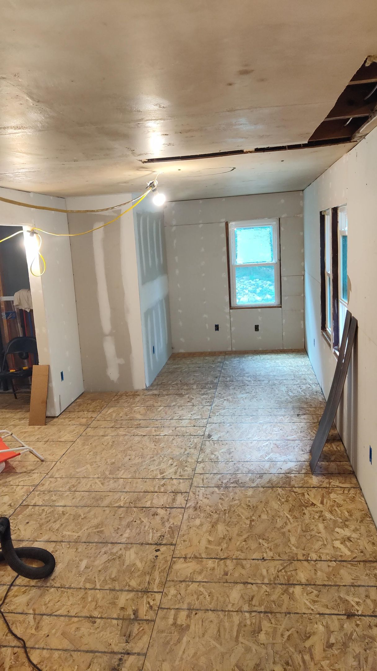 An empty room with a wooden floor and a window.
