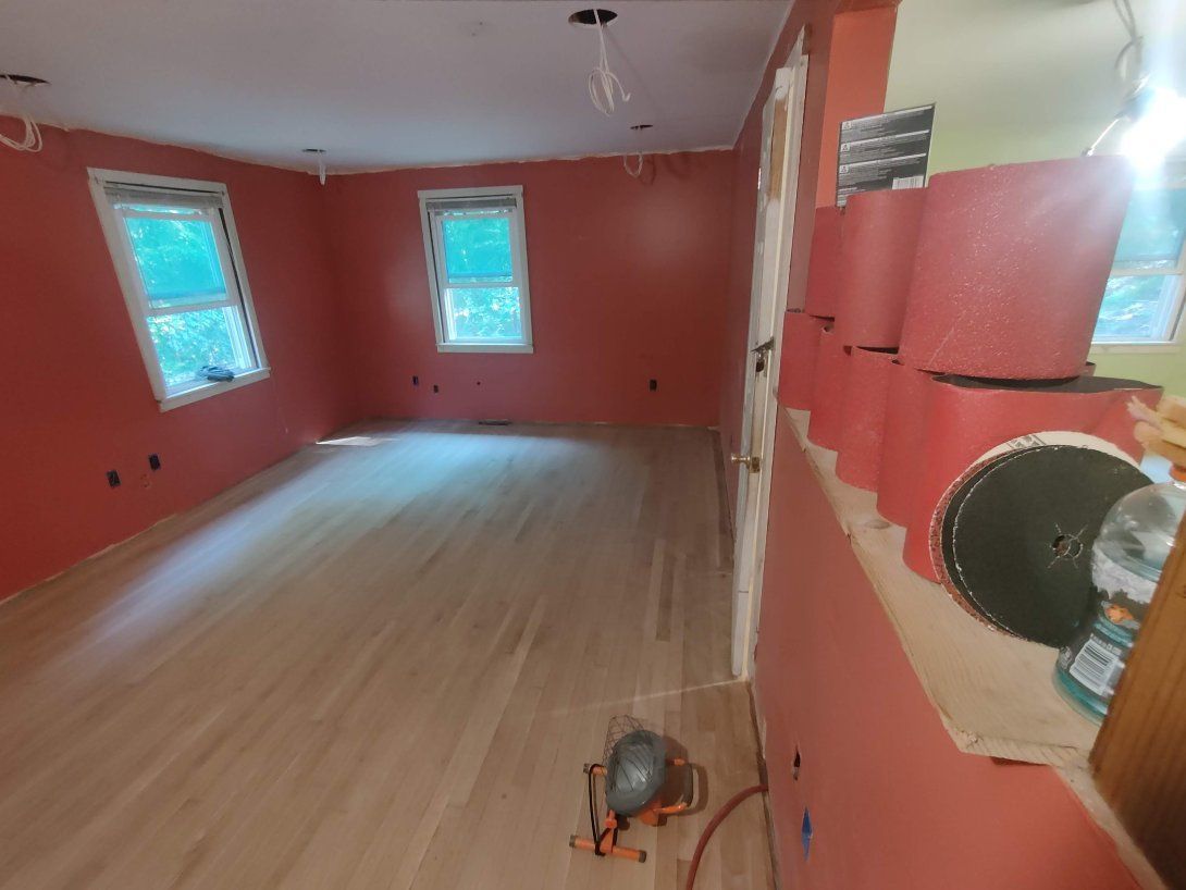 An empty room with hardwood floors and red walls.