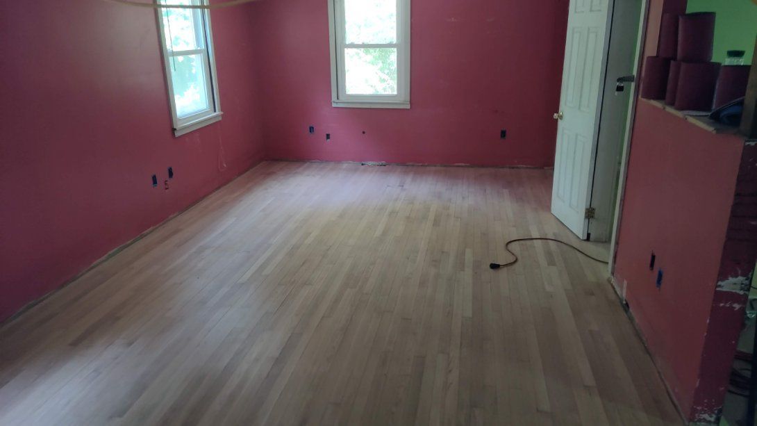A room with pink walls and a wooden floor.