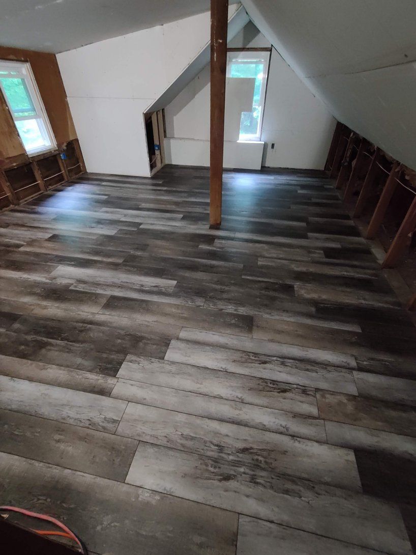 A room with a wooden floor and a window.