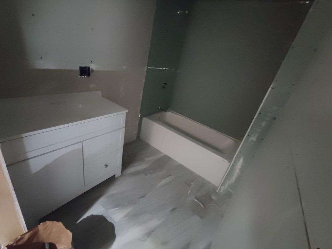 A bathroom with a sink , bathtub and shower.