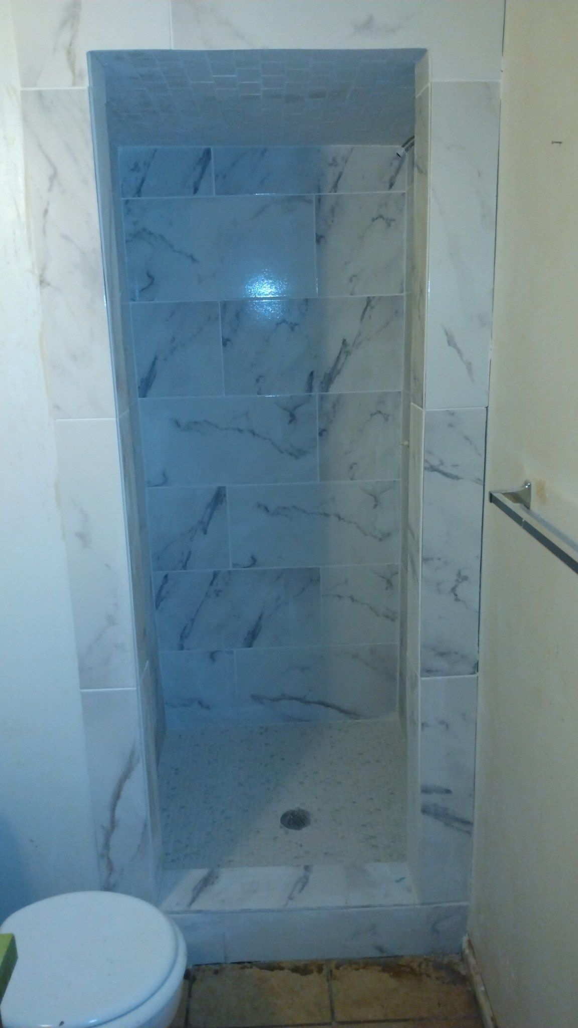 A bathroom with a toilet and a shower stall.