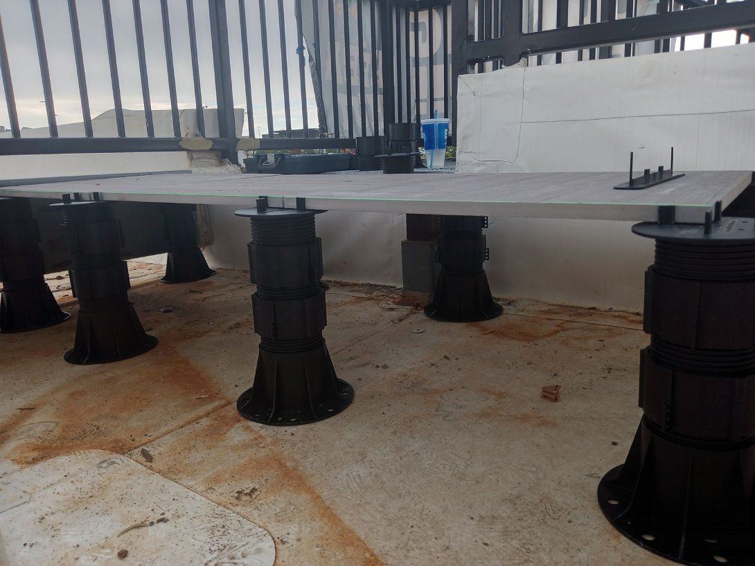 A bunch of black pillars are sitting on top of a concrete floor.
