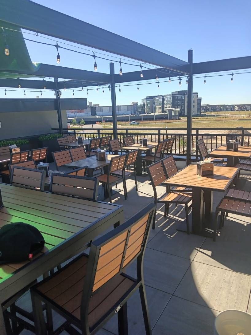 A patio with tables and chairs on a sunny day