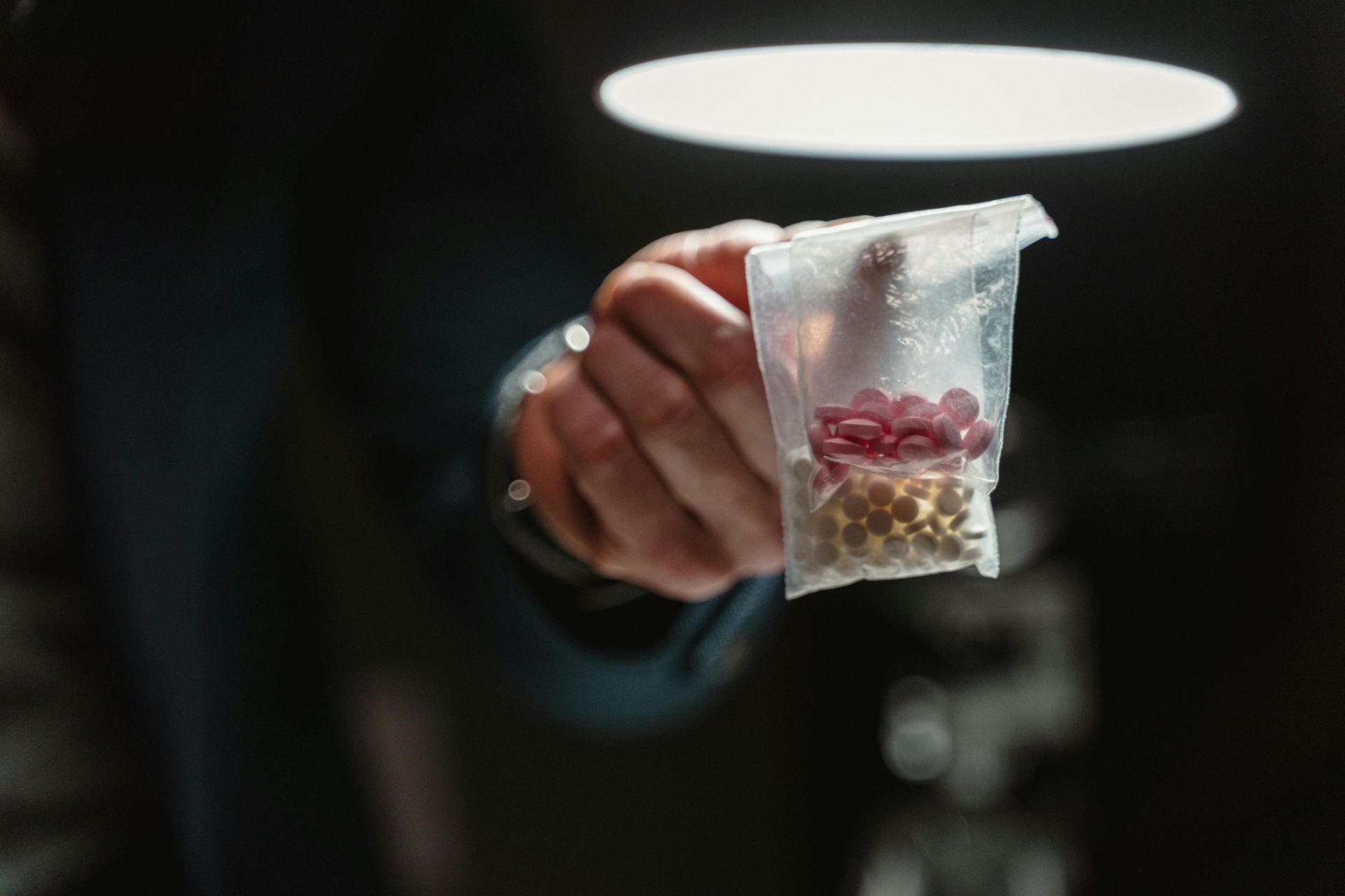 A person is holding a bag of pills in their hand.