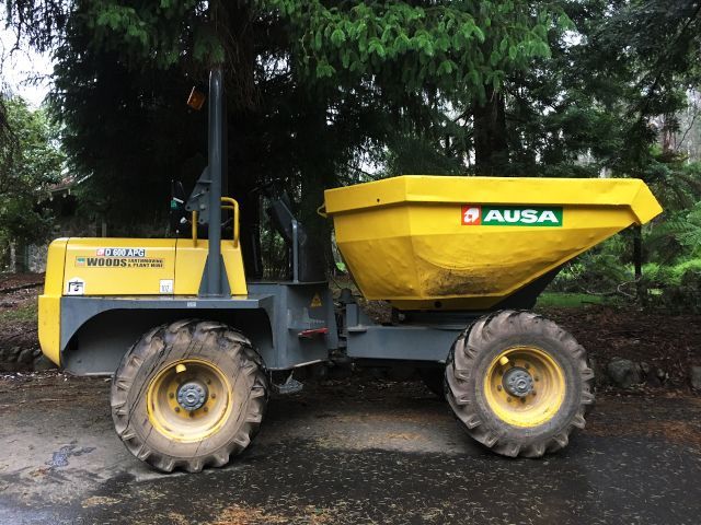 A yellow dump truck is parked on the side of the road.